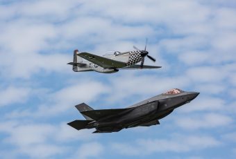 战争雷霆空战截图：美军P-51野马战斗机在蓝天白云中俯冲追击德军战机，机翼枪口火焰清晰可见